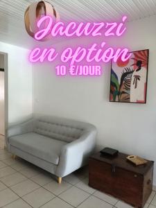 a room with a couch and a neon sign on the wall at Villa Korail Caraibes in Les Trois-Îlets
