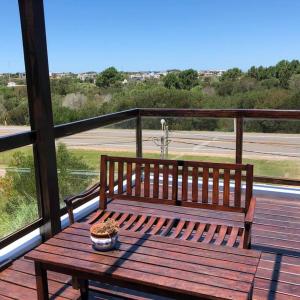 a wooden bench sitting on top of a balcony at IPB la Juanita Oeste in José Ignacio