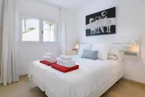 een witte slaapkamer met een bed met handdoeken erop bij Casa Anzuelo, Puerto del Carmen in Puerto del Carmen