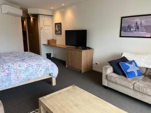 pokój hotelowy z łóżkiem, telewizorem i kanapą w obiekcie Waves 348 - Free WiFi - Late CheckOut - Garage w mieście Cowes