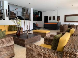uma sala de estar com cadeiras de vime e sofás em Hotel La Isla em Prado