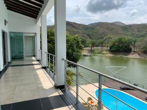 uma varanda de uma casa com vista para um rio em Hotel La Isla em Prado