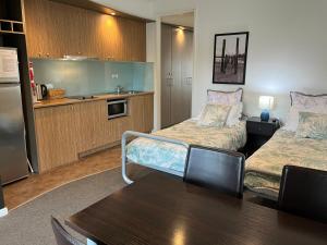 Habitación pequeña con 2 camas y cocina en Waves 348 - Free WiFi - Late CheckOut - Garage, en Cowes