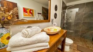 a bathroom with a sink and a shower with towels at Hotel Boutique Casa de Los Santos Reyes Valledupar in Valledupar