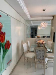 a dining room with a table and chairs and a mirror at Pe na areia frente mar in Balneário Camboriú