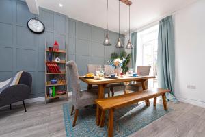 - une salle à manger avec une table et des chaises en bois dans l'établissement Explore Welsh Wonders at The Panache Stay, à Nelson