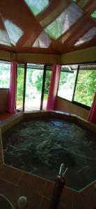 a large hot tub in a room with windows at Cabaña De Montaña Con Jacuzzi in Coto Brus