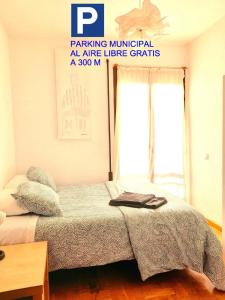 a bedroom with a bed and a sign that reads parking mindful at airlielie at NO FIESTAS, 5 DORMITORIOS Solo familias, parejas o trabajo PARKING Público Gratis a 300m in Toledo