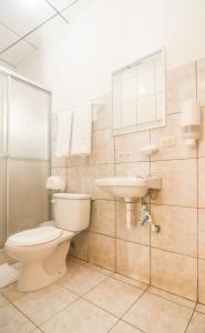 een badkamer met een toilet en een wastafel bij Hotel Aldea Chorotega Puntarenas in Puntarenas