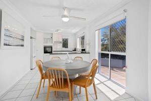 a kitchen and dining room with a table and chairs at Bilinga Beach House in Gold Coast