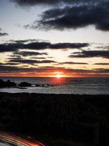 una puesta de sol sobre el océano con la puesta de sol en Beachport Motor Inn en Beachport