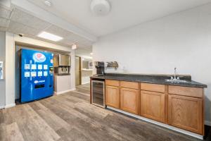 a large kitchen with a sink and a refrigerator at Executive Inn in Cass City