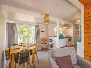 a living room with a table and a kitchen at Kaka Retreat - Taupo Holiday Home in Taupo