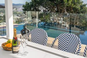 a table with a bottle of wine and a basket of fruit at Wave Hill and The Pool House in Lennox Head