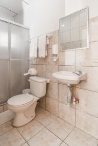 a bathroom with a toilet and a sink at Hotel Aldea Chorotega Puntarenas in Puntarenas