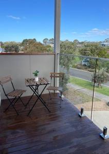 カウズにあるLuxurious, spacious beach houseのバルコニーにテーブルと椅子が置かれたパティオ