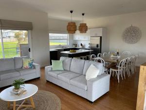 カウズにあるLuxurious, spacious beach houseのソファとテーブルとキッチンのあるリビングルーム