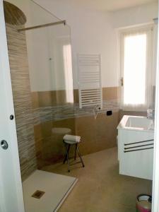a bathroom with a shower and a sink and a stool at Casa Antonella in Capovalle +8 photos