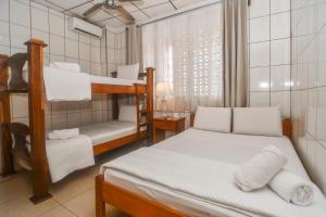 een slaapkamer met 2 stapelbedden en een raam bij Hotel Aldea Chorotega Puntarenas in Puntarenas