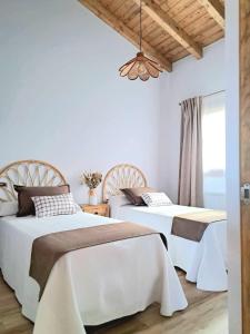 two beds in a bedroom with white walls and a ceiling at Terradeva Apartamentos in Colombres