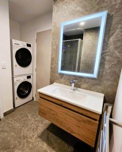 a bathroom with a sink and a washing machine at The Residences Ellerslie in Auckland