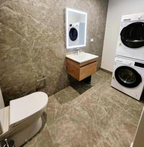 a bathroom with a toilet and a washing machine at The Residences Ellerslie in Auckland