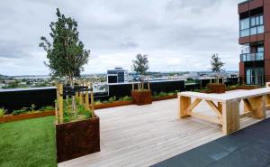 a wooden deck with a bench on top of a building at The Residences Ellerslie in Auckland