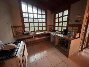una cucina con piano cottura, lavandino e finestre di CABAÑA EN MAZAMITLA a Mazamitla