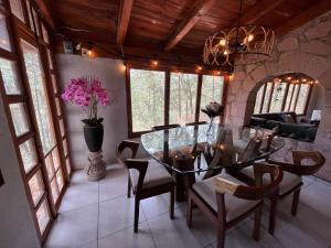 una sala da pranzo con tavolo e sedie in vetro di CABAÑA EN MAZAMITLA a Mazamitla