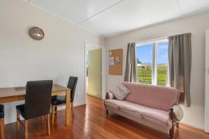 un soggiorno con divano e tavolo di Pickers Cottage - Mapua Holiday Unit a Upper Moutere