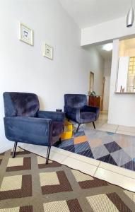 duas cadeiras azuis num quarto com um tapete em Studio Canadá: Custo-Benefício $ em Florianópolis
