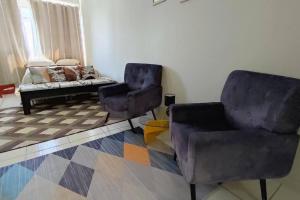 uma sala de estar com duas cadeiras e um sofá em Studio Canadá: Custo-Benefício $ em Florianópolis