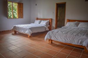 - une chambre avec 2 lits et une fenêtre dans l'établissement Villa Mipa Hotel y Restaurante, à Pueblo Bello