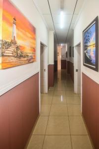a hallway in a hospital with a painting of a lighthouse at Hotel Aldea Chorotega Puntarenas in Puntarenas