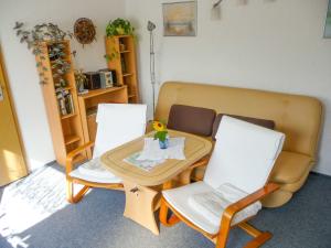 een woonkamer met een tafel en 2 stoelen bij Bungalow im Garten in Malchow