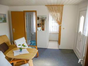 a small living room with a table and a chair at Bungalow im Garten in Malchow +1 photo