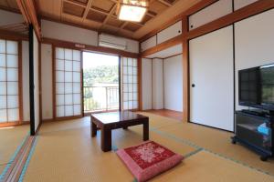 salon ze stołem i telewizorem w obiekcie Minshuku Satomachi w mieście Yakushima