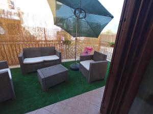 un patio con 2 sillas y una sombrilla en I Fiori di AminA Le Viole, en Pietramelara