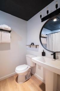 ein Badezimmer mit einem WC, einem Waschbecken und einem Spiegel in der Unterkunft Trailhead by Weekender 