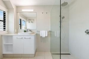 バイロンベイにあるByron Bay Beachfront Holiday Apartments Penthouse 10のシャワーと洗面台を備えた白いバスルーム