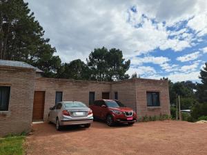 due auto parcheggiate di fronte a una casa di mattoni di NEco apartamentos Naturistas Nudistas Parejas o mujeres solas a Punta del Este