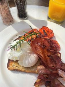 Victoria House Motor Inn في كرويدون: طبق من طعام الإفطار مع البيض لحم الخنزير المقدد والخبز المحمص