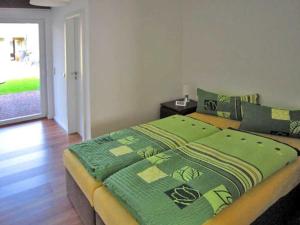 Un dormitorio con una cama con una manta verde encima. en Ferienwohnung Gartenstraße, en Malchow