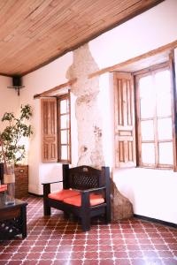Zimmer mit einer Bank in einem Gebäude mit Fenstern in der Unterkunft Lar Antiqua Hotel in Quetzaltenango