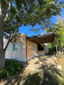 ein Haus mit einer Garage und einem Baum in der Unterkunft Bungalows palmar in Chajarí