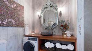 y baño con lavadora y espejo. en Cedar Cottage, en Canyonleigh