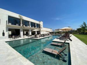 a swimming pool with chairs and umbrellas next to a building at 2BR/2B BEAUTIFUL CLOSE 5MIN TO CENTRO, POOL in San Miguel de Allende