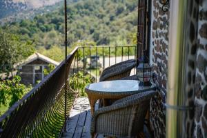 a porch with two chairs and a table on a balcony at Los Arbolitos Shared Housing in Güéjar-Sierra