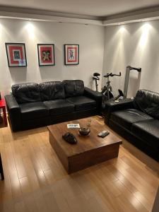 a living room with a black leather couch and a coffee table at No-taking-reservations in London