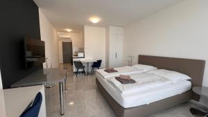 a bedroom with a large bed and a desk at Air conditioned 1 room Apartment Vienna Gate, 3 in Bratislava